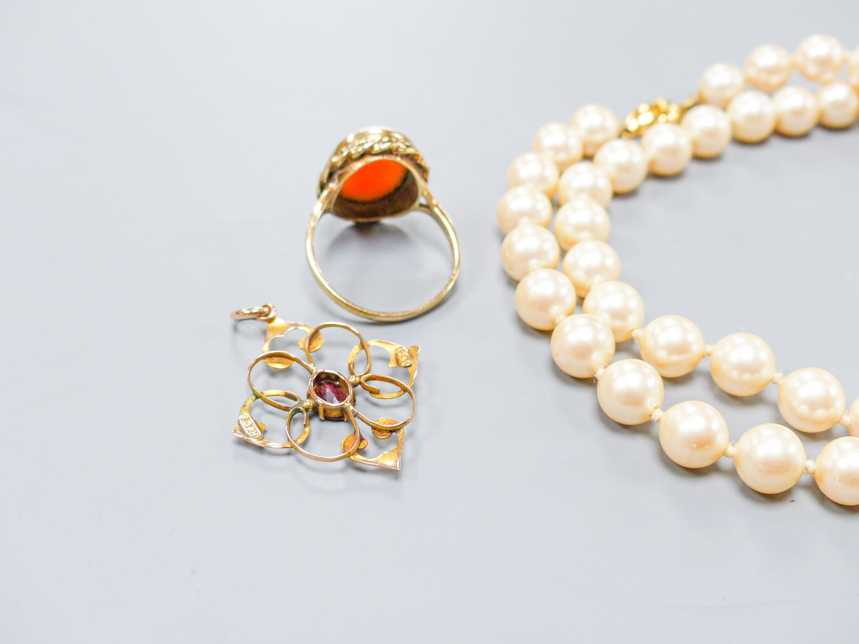 A 9ct gold and cameo shell oval ring, a 9ct and garnet set pendant and a simulated pearl necklace.